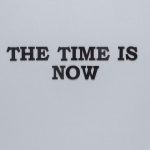 Minimalist poster with the motivational quote 'The Time is Now' on a gray background.